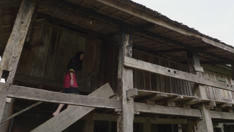 woman walking up the stairs of an old wooden house