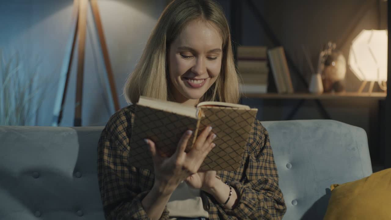 Donna che legge un libro a casa