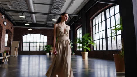 woman in beige jumpsuit modeling in industrial studio