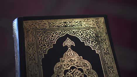 sunlight hitting cover of muslim quran islamic holy books shiny black and gold print