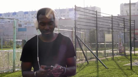 man listening to music on headphones in a city park
