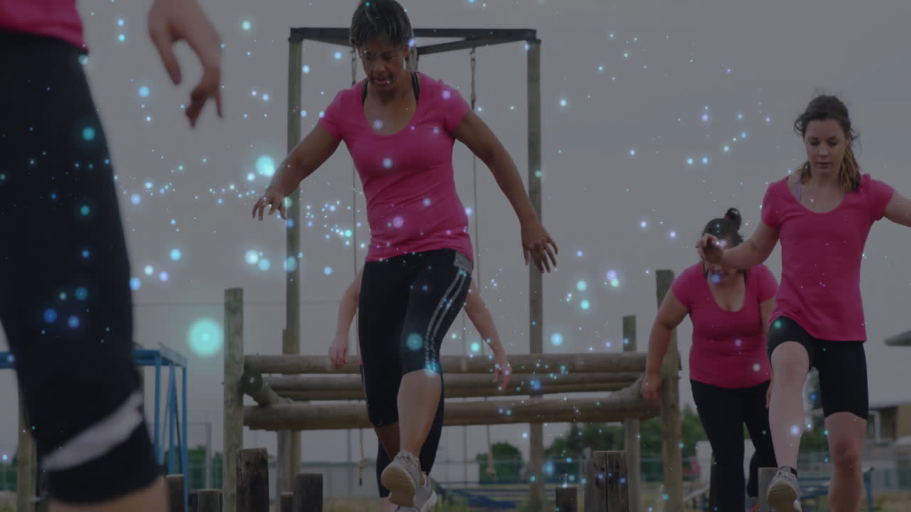 Women in pink shirts exercising outdoors with sparkling light animation over them