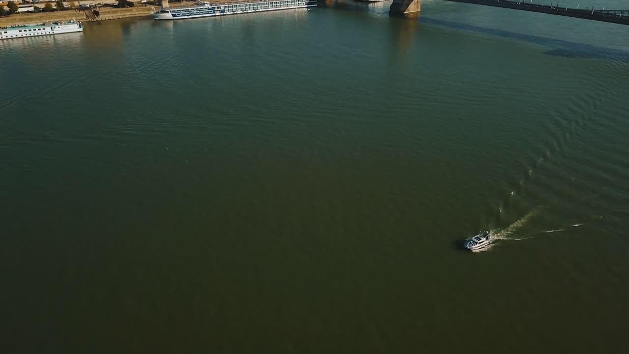 Aerial view of a river with a boat and a bridge