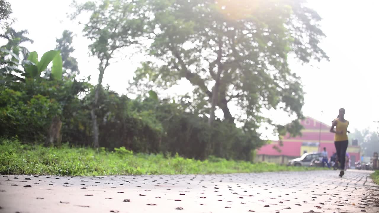 일출이나 일몰 때 도로를 달리는 어린 소녀, 슬로우 모션, 낮은 앵글 샷