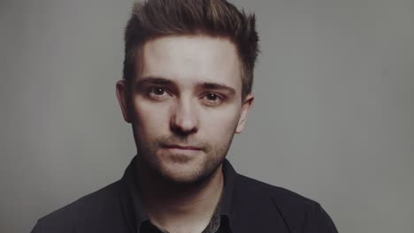 fashion portrait of young man. fashion portrait of young man in black shirt poses over wall