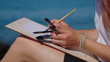 woman painting outdoors on the beach