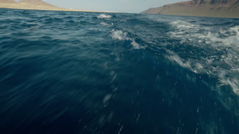 Olas-Detrás-De-Un-Barco-En-Movimiento-Rápido-Con-Islas-En-El-Fondo