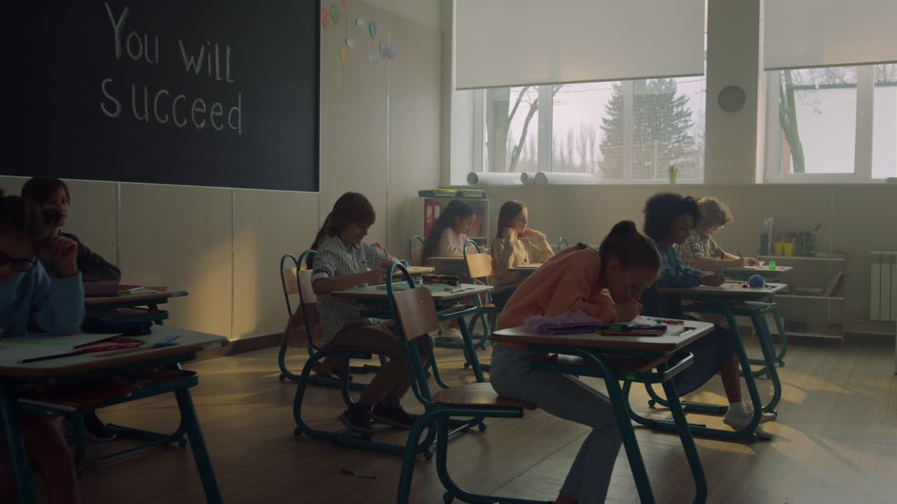Schoolchildren studying in school class. Students doing class work in auditorium