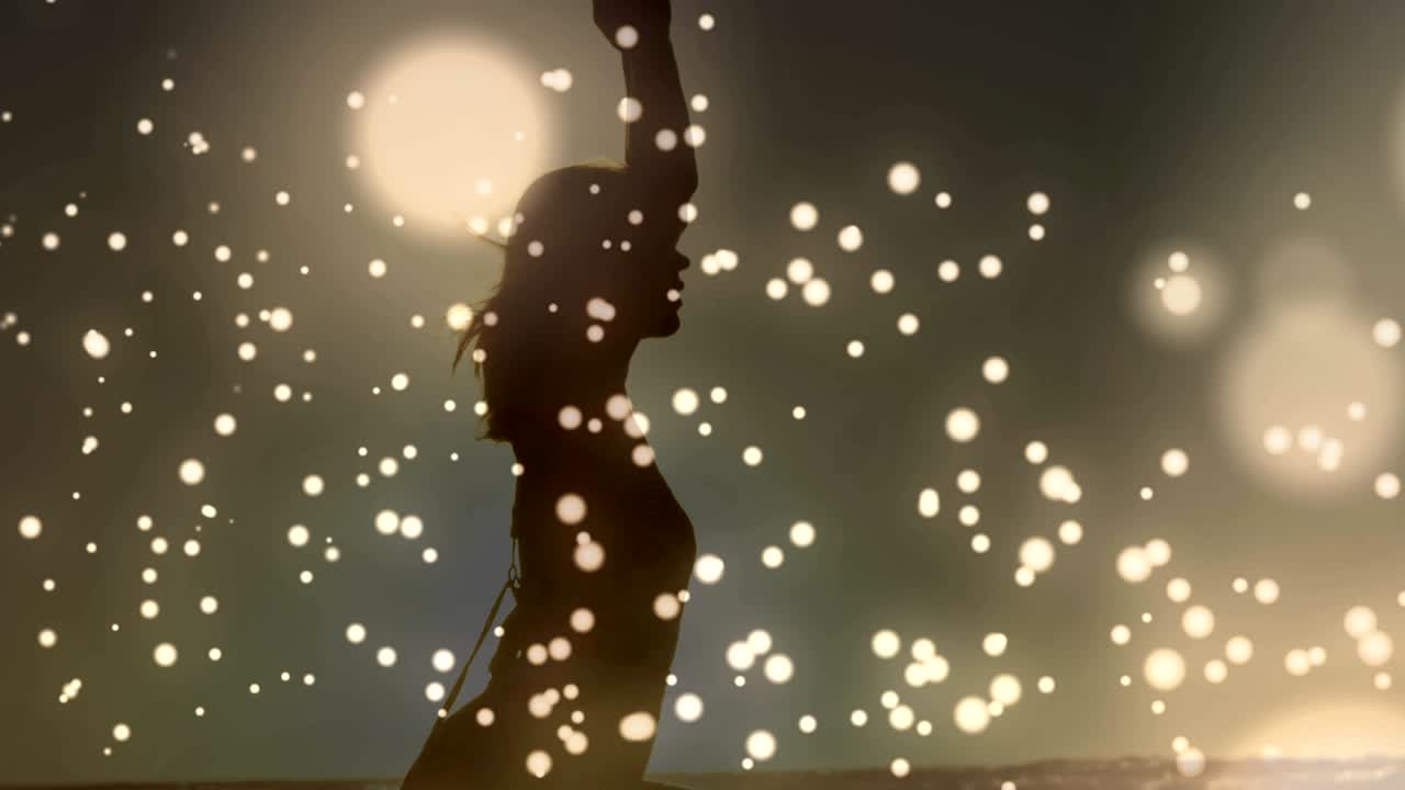 요가를 하는 여성의 배경에 반대하여 움직이는 황금빛 반이는 반점