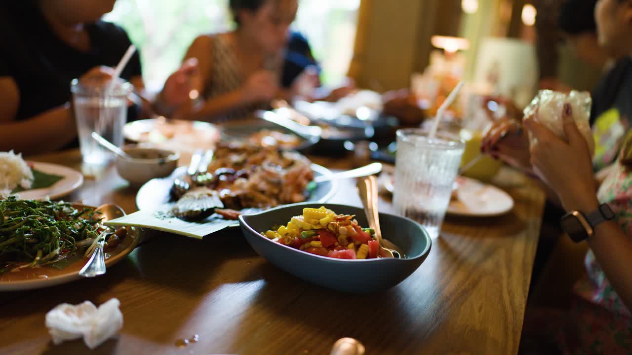 A group of people dining together at a table with various dishes