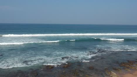 Aerial-footage-filmed-with-a-drone-overlooking-the-beach-and-sea-of-crashing-waves-with-a-deep-blue-ocean-on-the-Bluff-in-Africa-southern-hemisphere