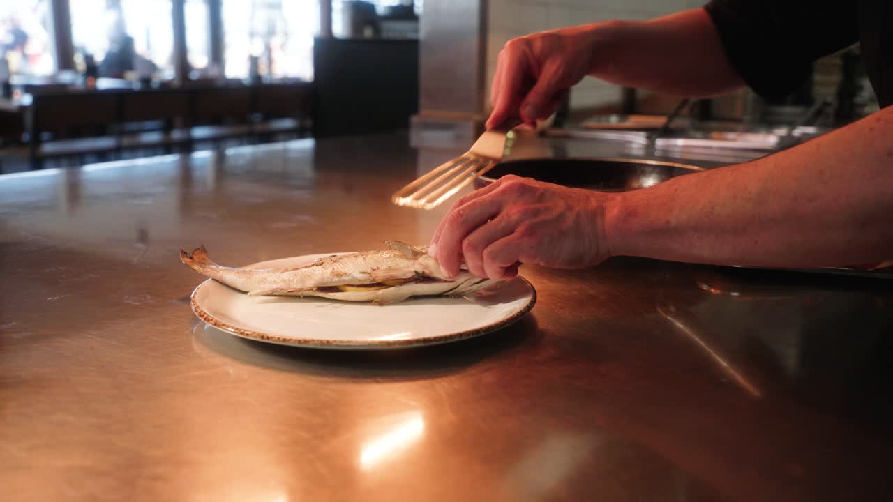 Un pesce che viene messo su un piatto e preparato