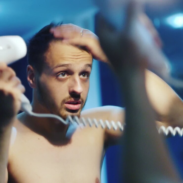 Young Man Dries Head With Hair Dryer 01