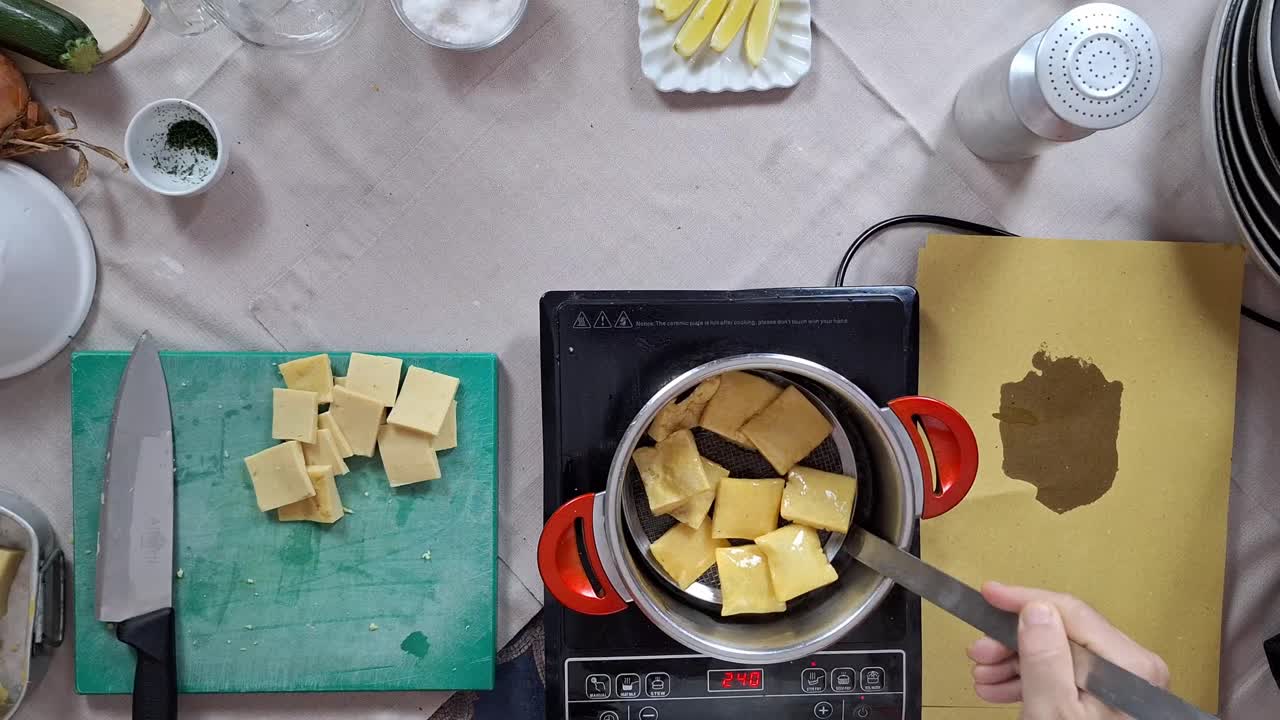 fritas de panela hechas de harina de chickpea que el chef saca con un tamiz