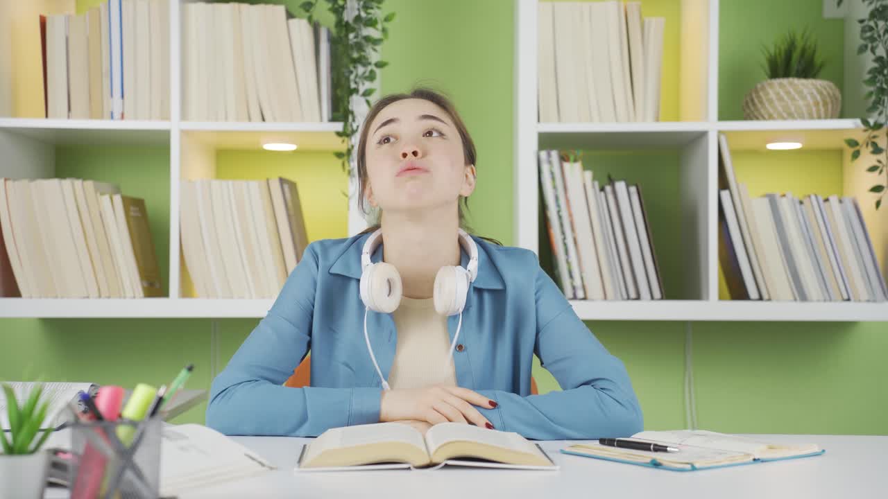 지루한 여학생이 음악을 듣고 있습니다.