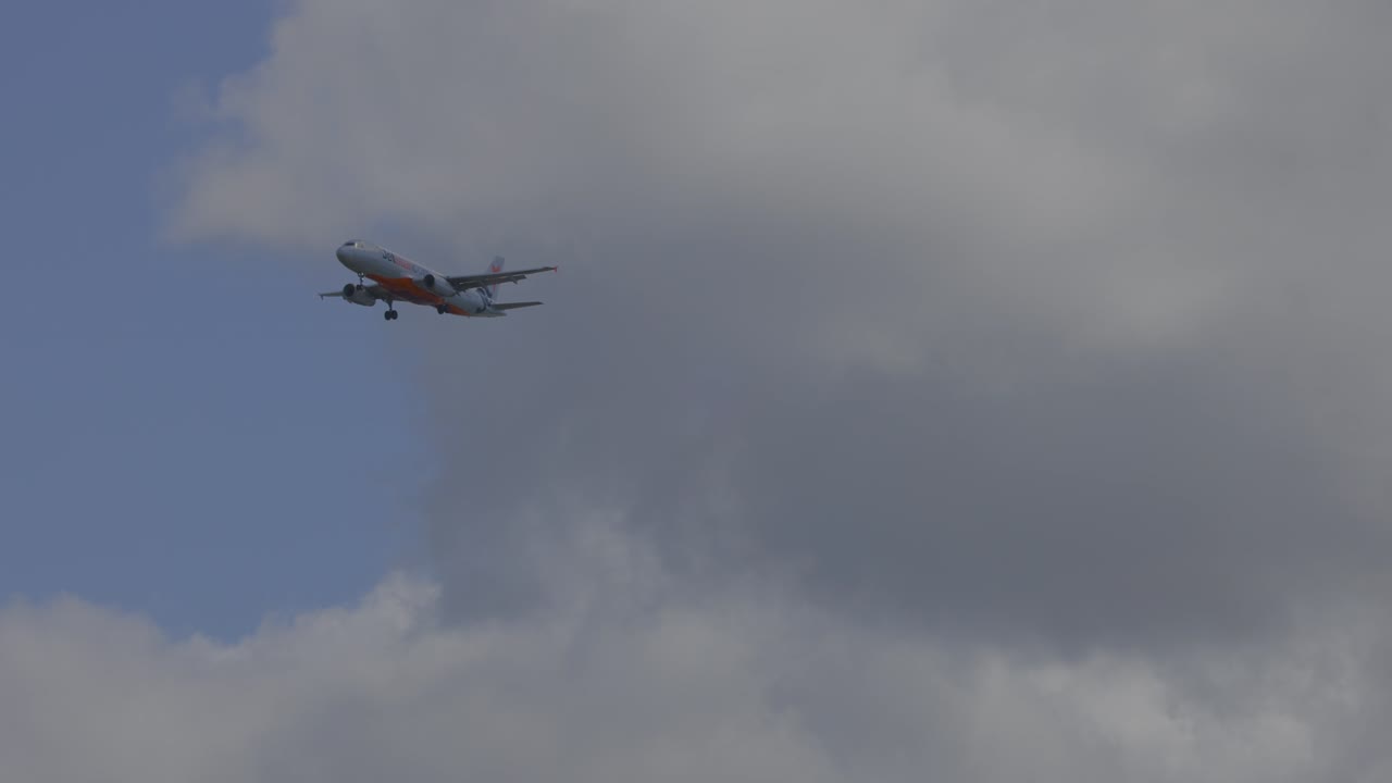 avión volando a través del cielo nublado en la playa de currumbin