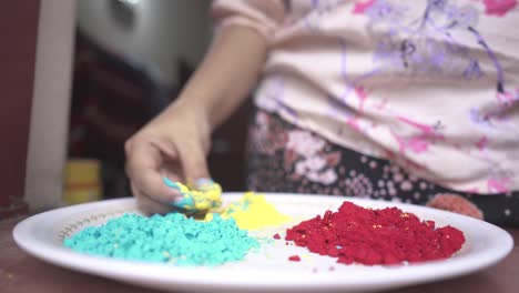 Mano-De-Niña-Jugando-Con-Polvos-De-Color-En-El-Plato-Dentro-De-Casa-Debido-Al-Bloqueo-Del-Coronavirus,-Cámara-Lenta