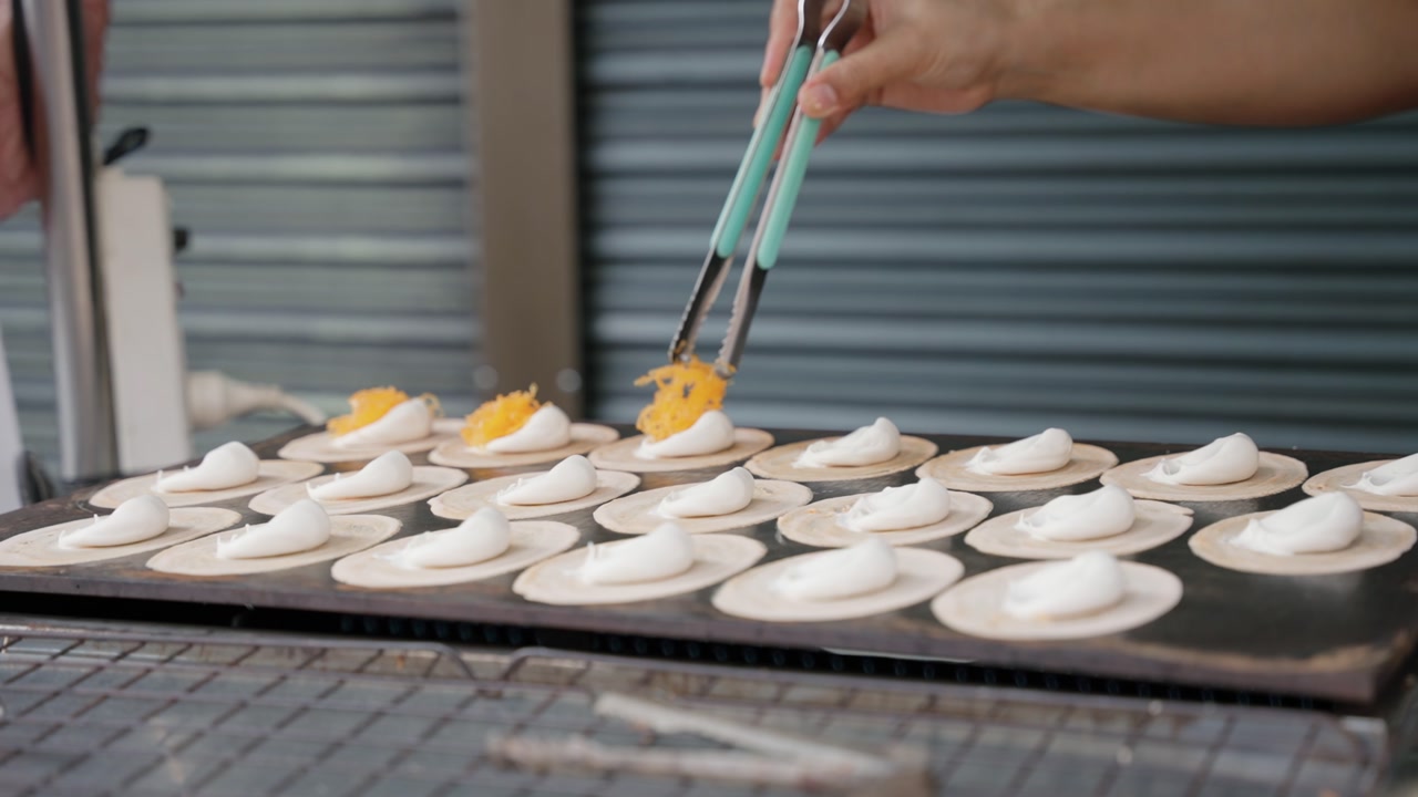 Kanom Buang, often called Thai crispy pancakes, is a traditional Thai street snack made with thin, crisp shells filled with sweet or savory toppings