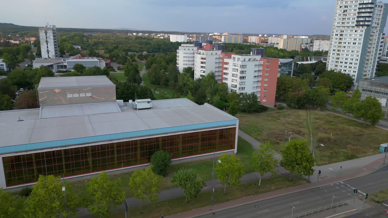 halle neustadt in germany, tramway station and the distinctive swimming pool building with its colorful mural. Dramatic aerial view flight panorama orbit drone
