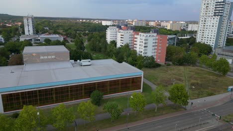 halle neustadt in germany, tramway station and the distinctive swimming pool building with its colorful mural. dramatic aerial view flight panorama orbit drone