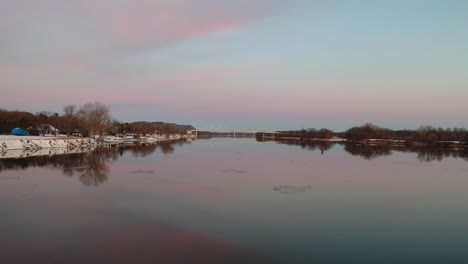 winter sunrise over a river with bridge reflection