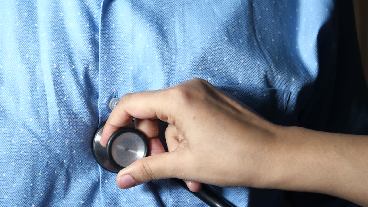 Doctor examining patient's chest with stethoscope