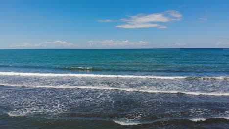 Türkisfarbenes-Meerwasser-Und-Weiße-Wellen,-Die-An-Einem-Sommertag-Mit-Strahlend-Blauem-Himmel-Am-Ufer-Der-Adria-Schäumen