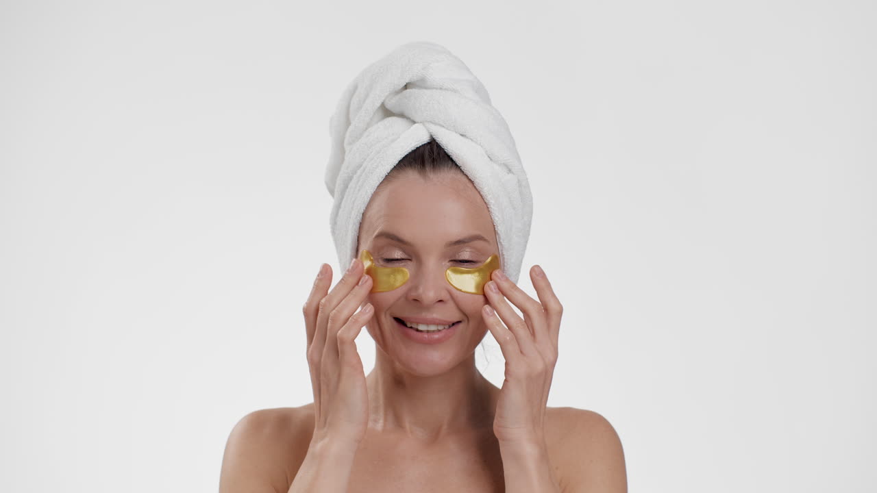 Woman applying gold eye patches