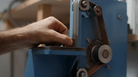 man using belt sander