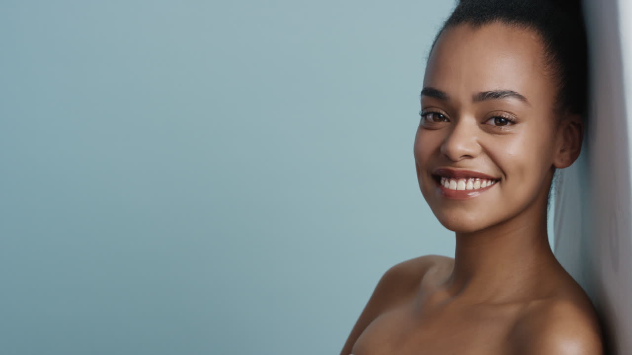 portrait beautiful young african american woman with smooth healthy skin looking sensual attractive female enjoying healthy skincare beauty on blue background copy space