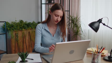 young business woman works on laptop makes online purchases, study, e-learning, remote job at office