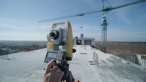 geodetic works. surveyor engineer in protective wear and red helmet using geodetic equipment at construction site. professional equipment.