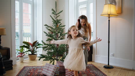 Lustiges-Kind,-Das-Im-Weihnachtsbaumzimmer-Spielt.-Lächelnde-Mutter-Gibt-Fünf-Töchtern