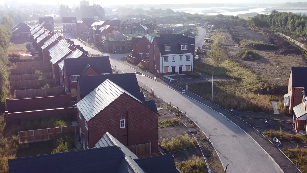 Luftfoto under morgensolopgang over en britisk byggeplads for et boligområde under udvikling