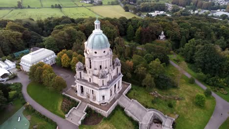 Historic-Ashton-memorial-English-domed-folly-landmark-Lancashire-countryside-sunrise-Aerial-descending-tilt-up-view