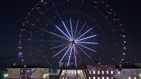 ferris wheel with glowing multicolored lights against the night sky.