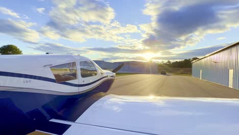 Privatpilot-Steigt-Vom-Flügel-Der-Piper-Cherokee-180-Ab,-Mit-Sonnenuntergang-Im-Hintergrund