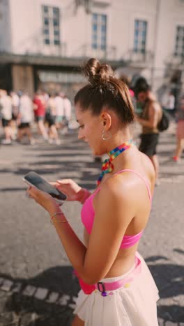 woman looking at phone at a pride parade