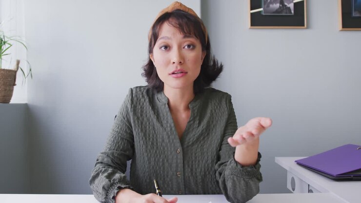 Ritratto di donna d'affari birazziale che parla e guarda in camera in ufficio