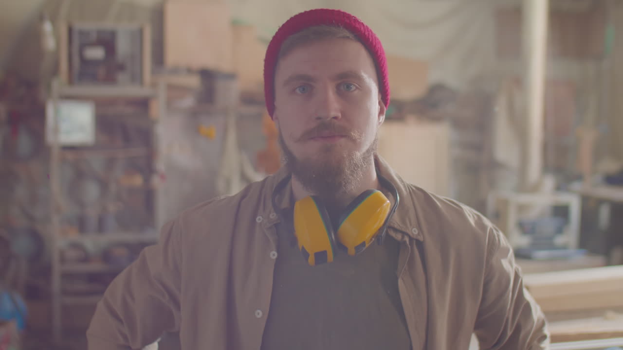 Portrait of Woodworker with Safety Earmuffs in Workshop