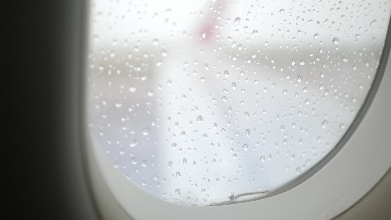 객실 내부에서 비행기 창 표면에 빗방울