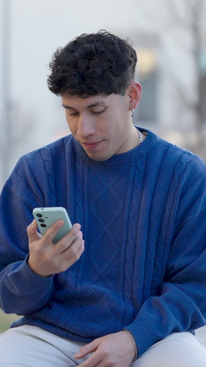 Young man expressing various emotions while using smartphone. Vertical