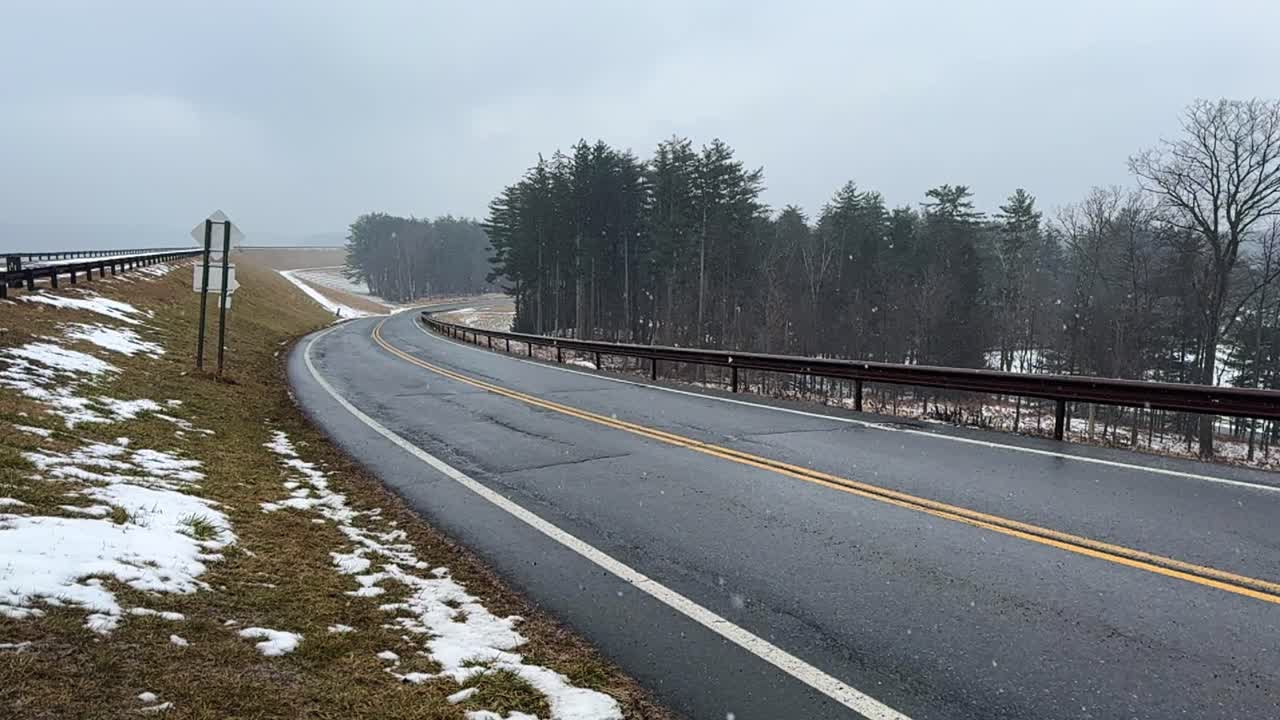 Gentle, beautiful snowfall at the beginning of of a big nor’easter on a road in the Catskill mountains – slow motion