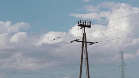 two birds are sitting on high voltage wires