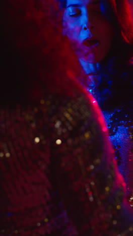 Vertical-Video-Of-Two-Women-In-Nightclub-Bar-Or-Disco-Dancing-With-Sparkling-Lights-In-Background-4