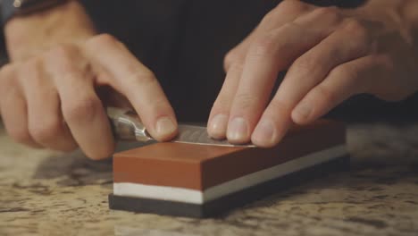 Sharpening-Knife-With-Whetstone.-closeup