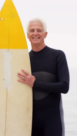 mature man holding surfboard