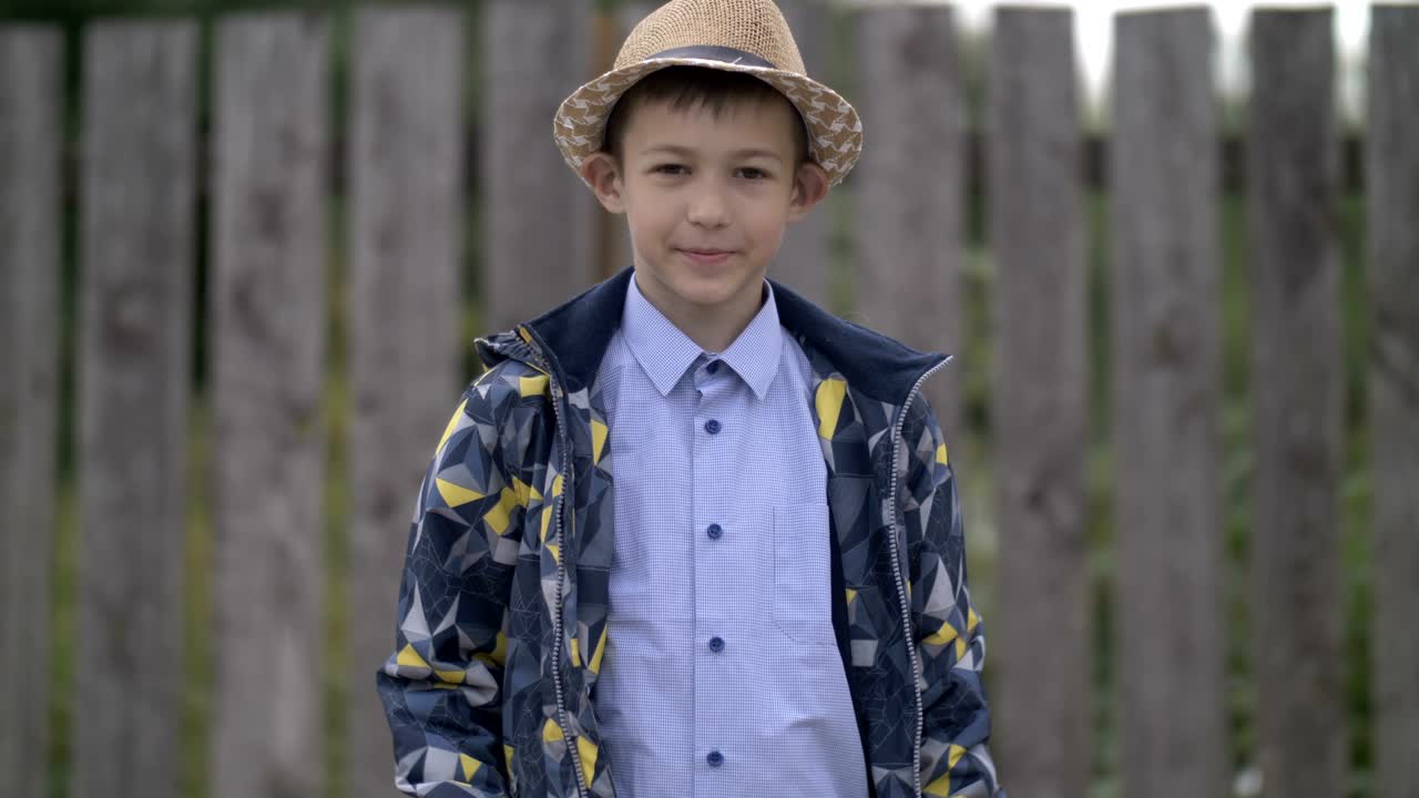 счастливый мальчик в шляпе показывает свою руку классу