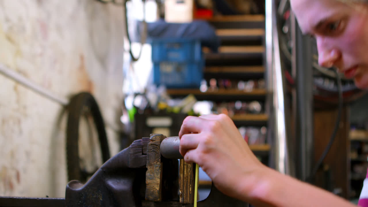 mujer midiendo una herramienta de bicicleta en el taller 4k