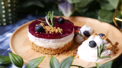 cheesecake with berry sauce set on wooden plate.